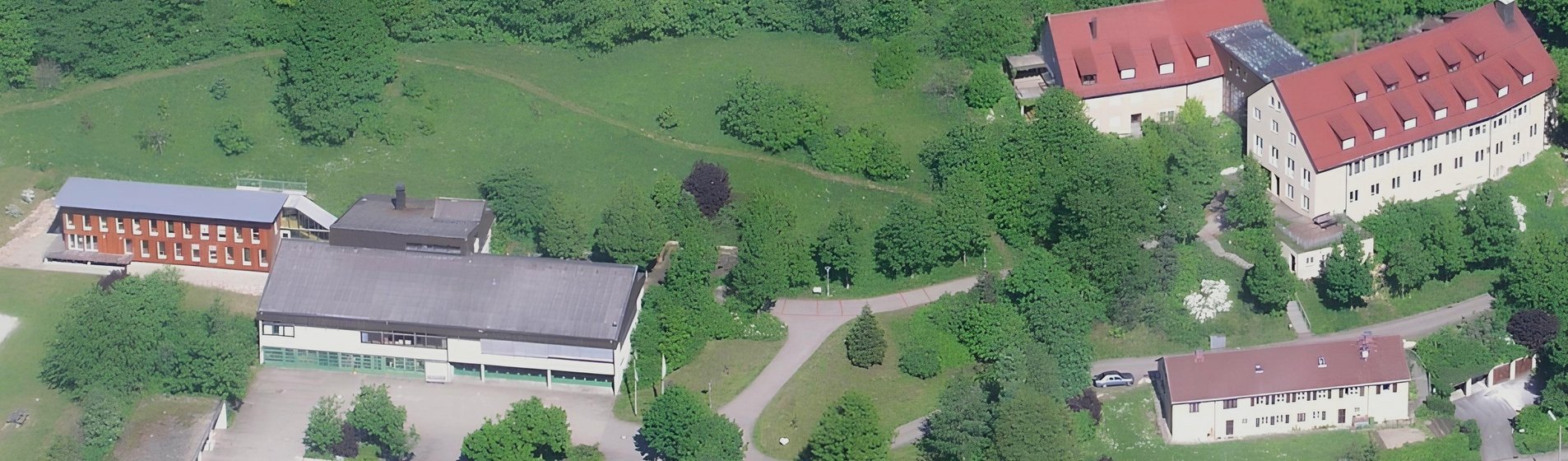 Luftbild der Gesamtanlage des FBZ mit drei Gebäuden rechts und einer großen Halle links.